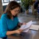 Un periodista revisa papeles y archivos en la sala de redacción, preparándose para su próxima nota.