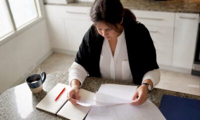 Periodista revisando documentos oficiales para confirmar la veracidad de una noticia en su escritorio.