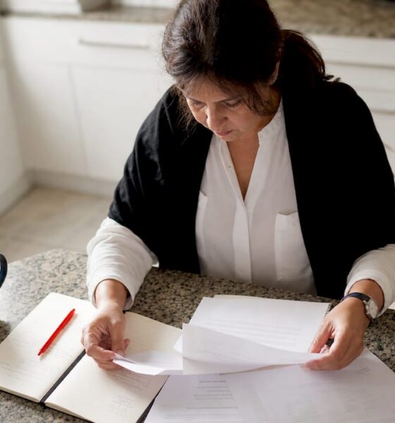 Periodista revisando documentos oficiales para confirmar la veracidad de una noticia en su escritorio.