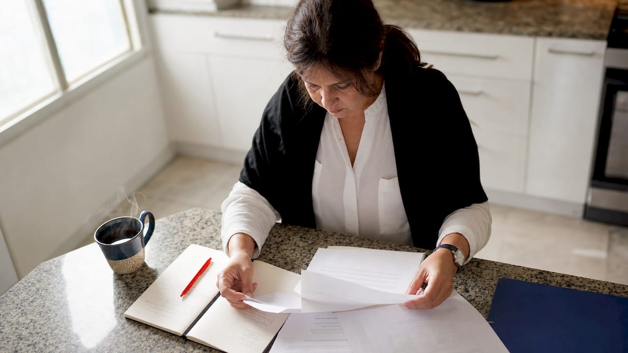 Periodista revisando documentos oficiales para confirmar la veracidad de una noticia en su escritorio.